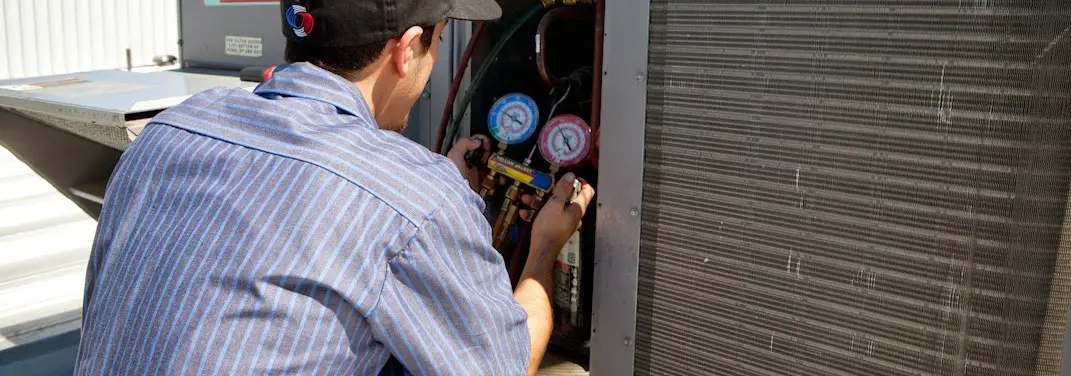 HVAC technician servicing a condenser unit in Lealman
