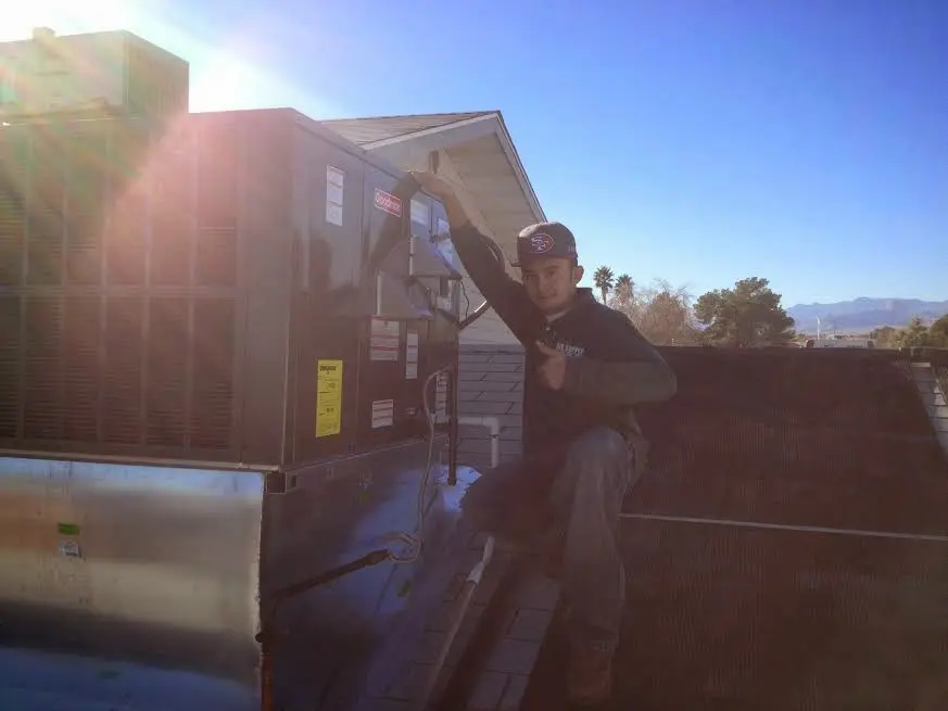 HVAC technician performing AC Tune-Up on a rooftop unit in Lealman